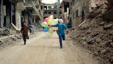 فتاتان تلهوان في شارع دمرته الحرب